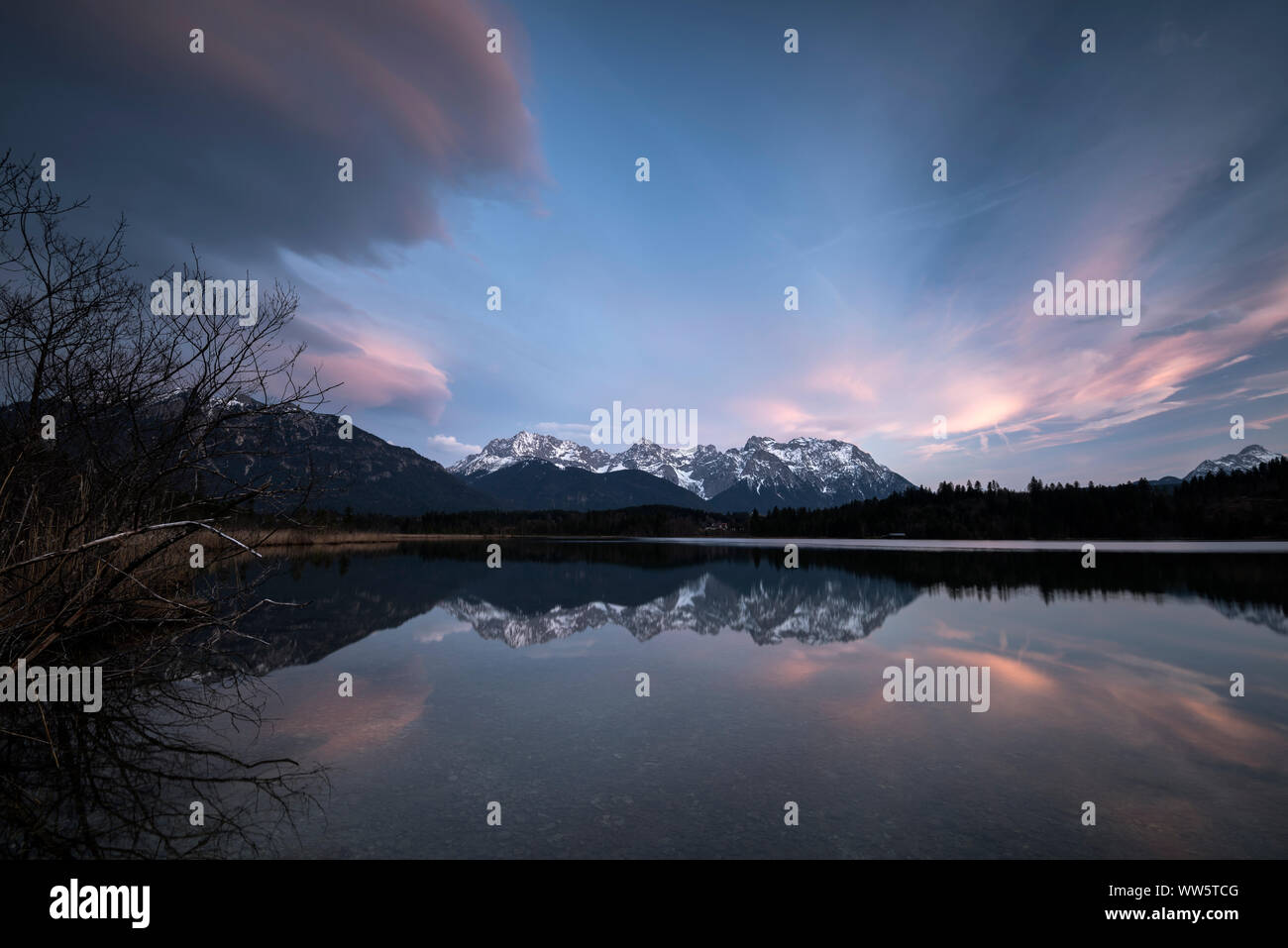 Reflexion der westlichen Karwendelgebirge im Barmsee. Von links dramatische Wolken kommen, die Alpen etwas Schnee. Stockfoto