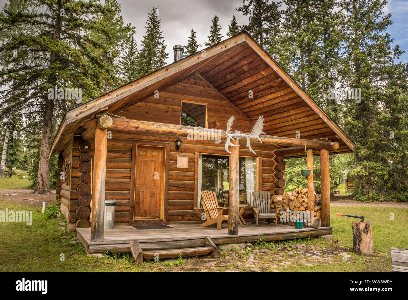 Blockhaus von außerhalb mit Geweih und Brennholz stack, British Columbia, Kanada Stockfoto