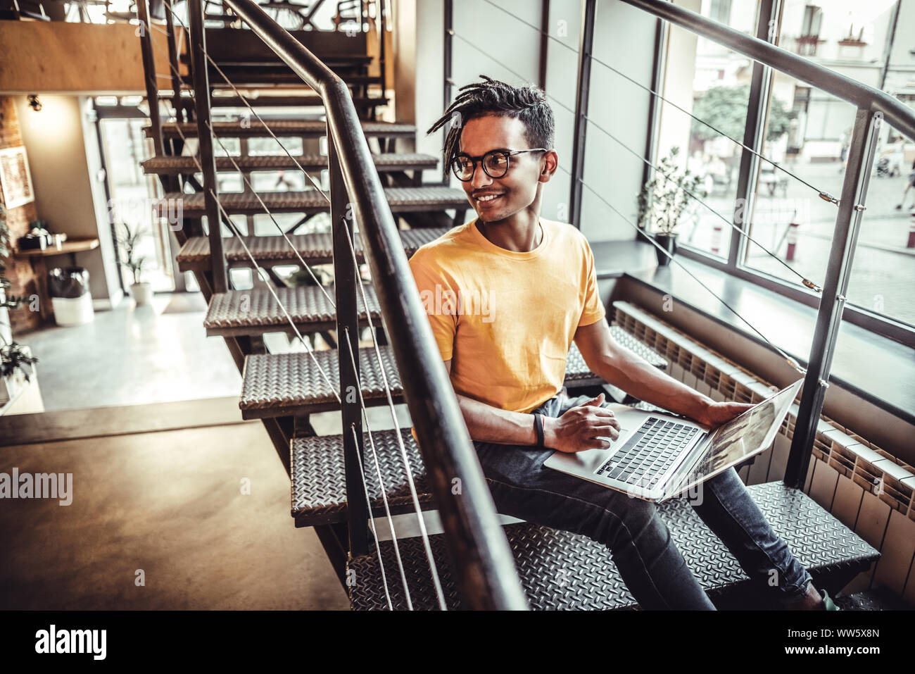 Junge Inder sitzen im Coffeeshop Tisch und Arbeiten am Laptop. Das Konzept der Studie, freiberuflich, Arbeit, Technologie Stockfoto