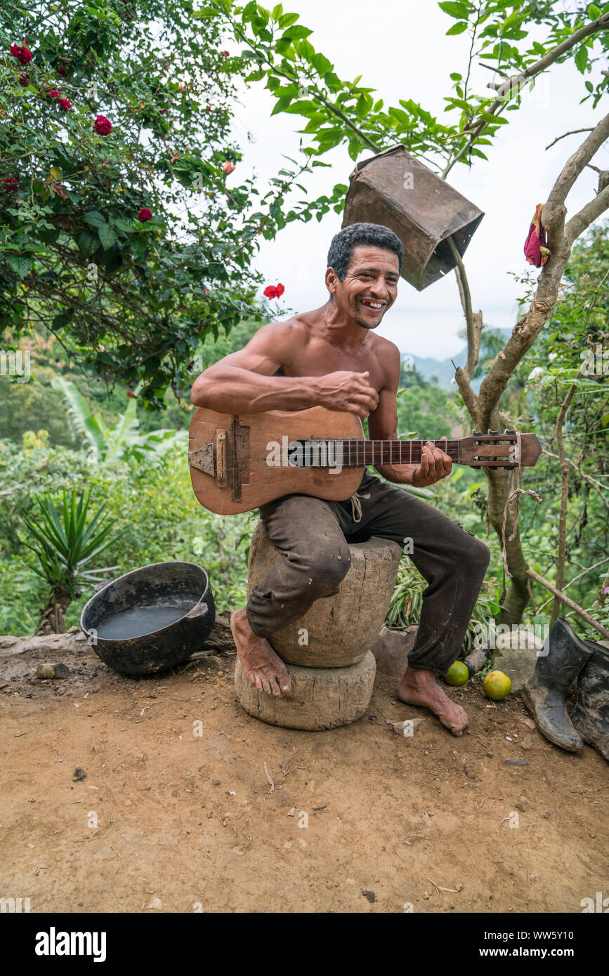 Ein Mann spielen auf einem Selbstgebauten Gitarre, Bergbauernhof in der Sierra Maestra Stockfoto