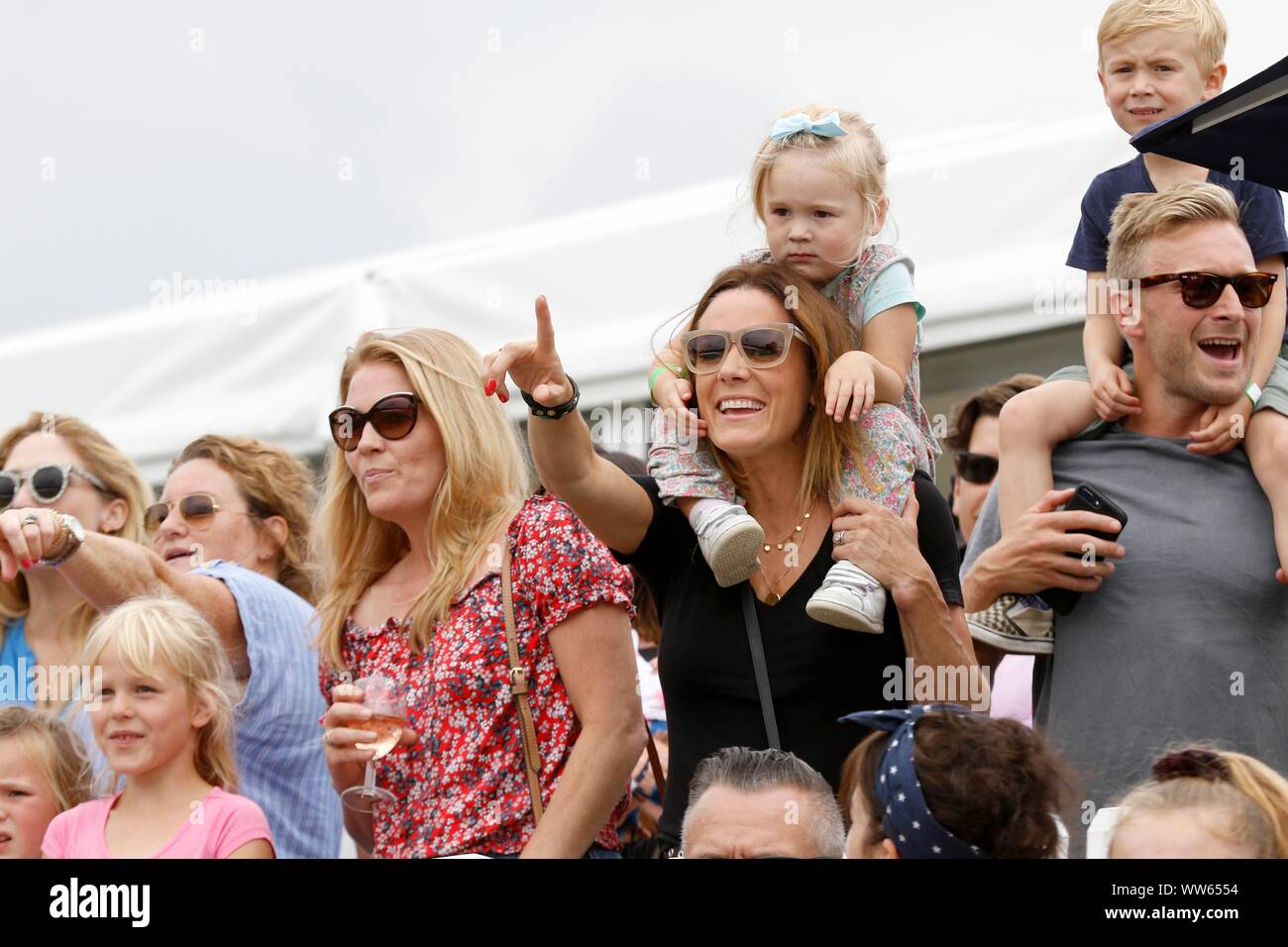 Herbst Phillips, links, ihre Tochter Isla auf den Schultern von Natalie Pinkham, der F1-Fernsehmoderatorin, und beobachtet den Shetland Pony Grand National. Stockfoto