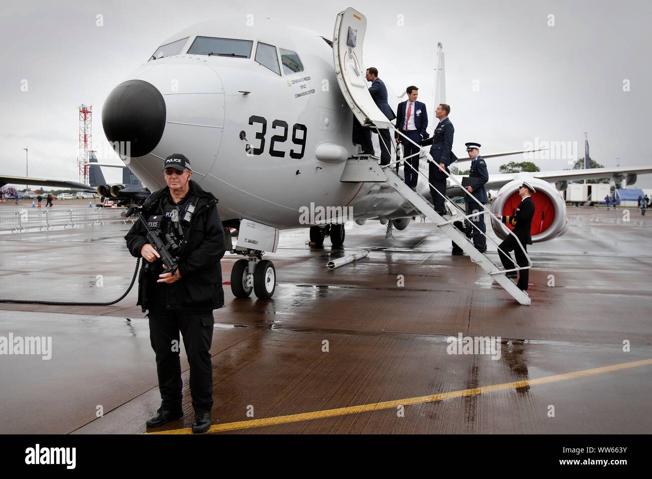 Bewaffnete Polizisten patrouillieren die Show, als VIP-Party besuchen Sie ein Flugzeug der US Navy. Regen, niedrige Wolkenuntergrenze und starke Winde alle aber stoppt die Flugvorführungen auf Frida Stockfoto