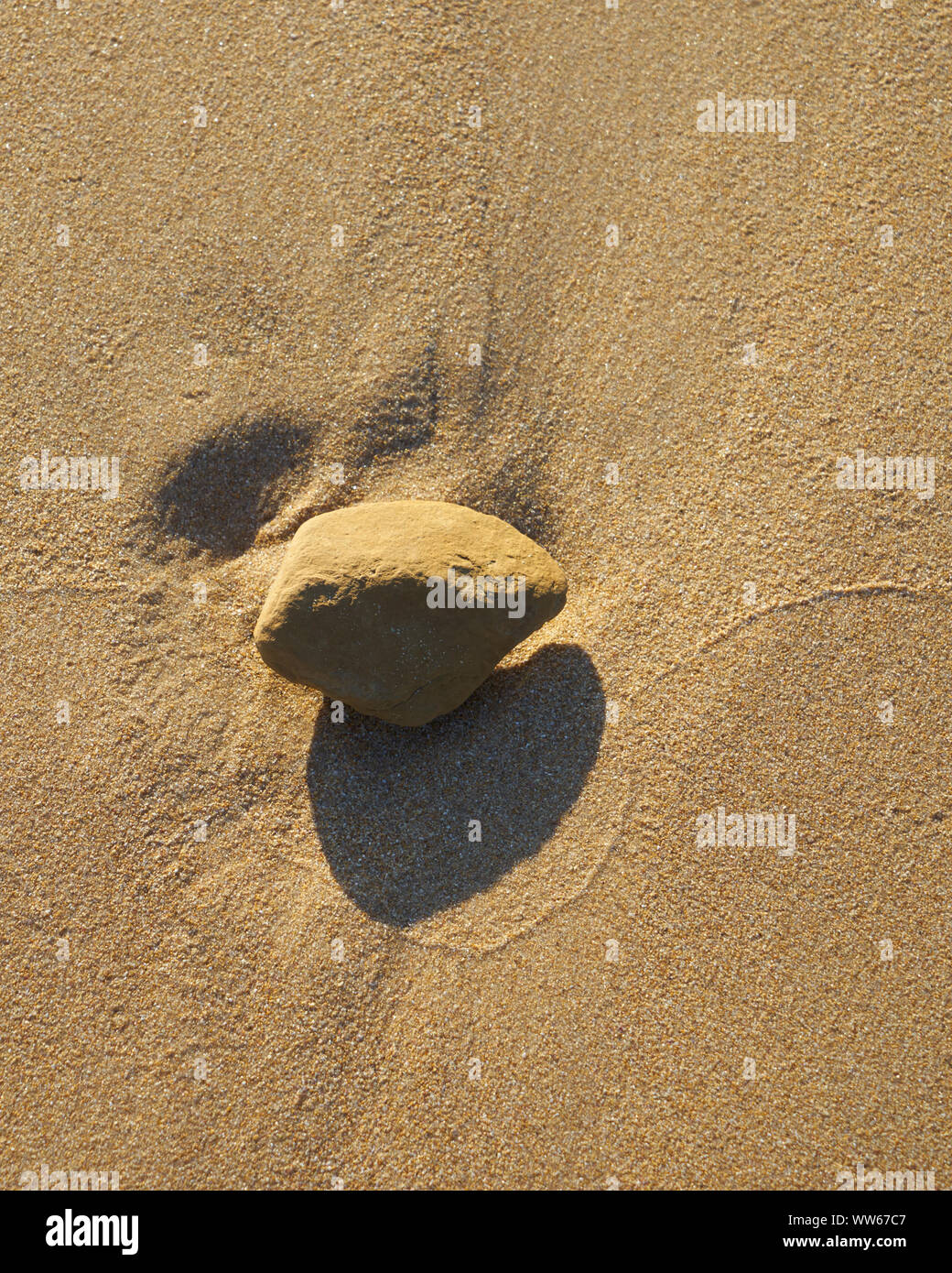 Stein mit Verbindung als eine Linie im Sand Stockfoto