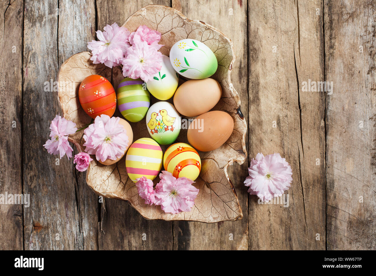 Schüssel mit Ostereiern und Kirschbäume auf hölzernen Boden Stockfoto