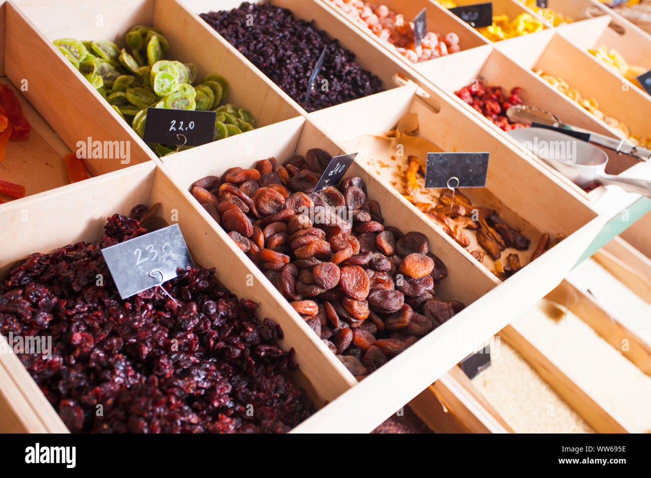 Vielzahl von getrockneten Beeren und Früchte in kleine Familie Shop. Getrocknete Cranberries, Aprikosen, Kiwi, unter anderen trockenen Früchte in den Holzkisten. Stockfoto