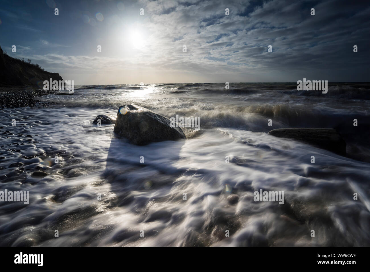 Ostsee am Abend licht und lange Belichtung, untergehende Sonne leuchtet Steine im Meer Wasser Stockfoto