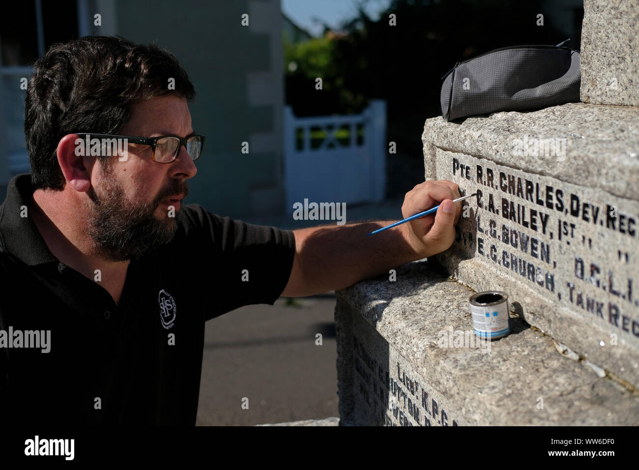 Ein Zeichen Schriftsteller, Maler arbeiten an einem Kriegerdenkmal im Chilcompton, Somerset. Stockfoto