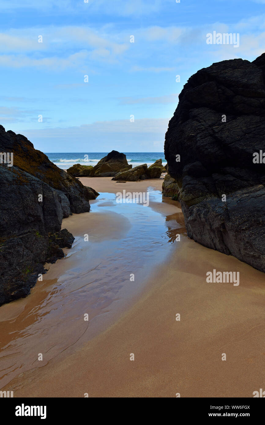 Einfache Meereslandschaft mit unberührten Sand, große Steine und Weg zum Ozean mit blauer Himmel, bei Durness, Scottish Highlands, Nordküste 500 Route Stockfoto