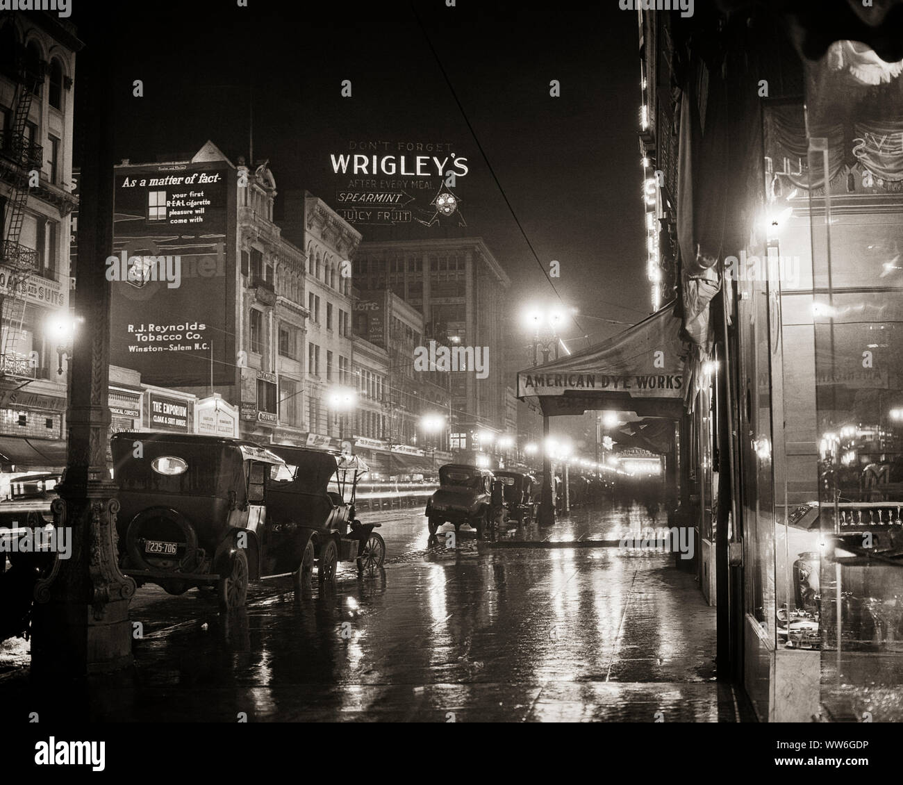 1920 s Regen nass CITY NIGHT SCENE helle Lichter und geparkte Autos THEATER AM BROADWAY LOS ANGELES Kalifornien USA-q 45914 CPC 001 HARS VERSUCHUNG HELLE ENTDECKUNG FREIZEITAKTIVITÄTEN UND AUTOS AUFREGUNG AUSSEN NIEDRIGEN WINKEL MÄCHTIGE FORTSCHRITTE ERHOLUNG KANN VERBINDUNG KONZEPTIONELLE AUTOMOBILE STILVOLLE FAHRZEUGE FILM THEATER BROADWAY KREATIVITÄT GROSSEN KINOS SCHWARZE UND WEISSE BEZIRK LOS ANGELES ALTMODISCHE DURCHGANGSSTRASSE Stockfoto