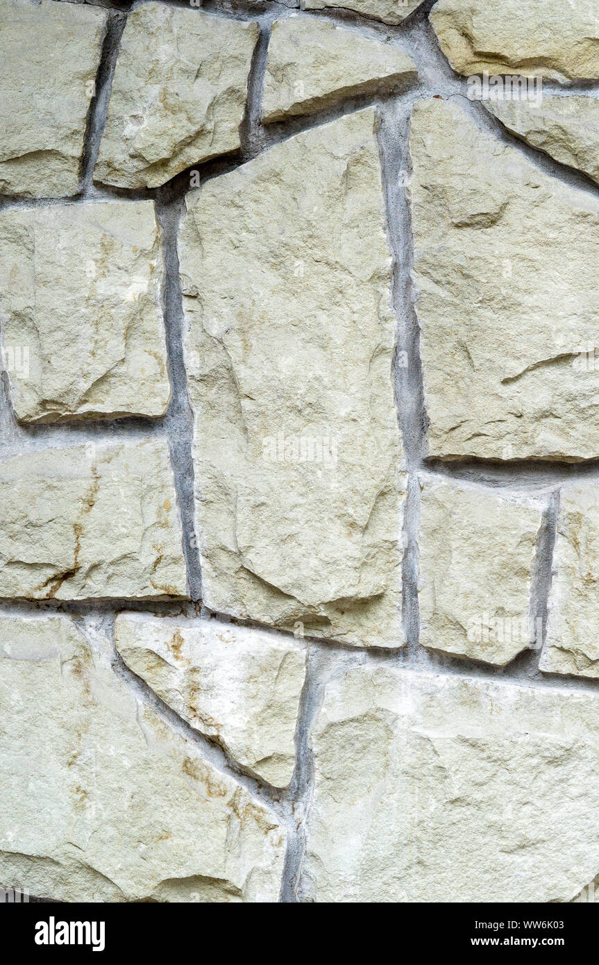Die vertikale Wand ist mit einem rauen, grob gehackt Stein konfrontiert. Natürliche Hintergrund für Designer. Stockfoto