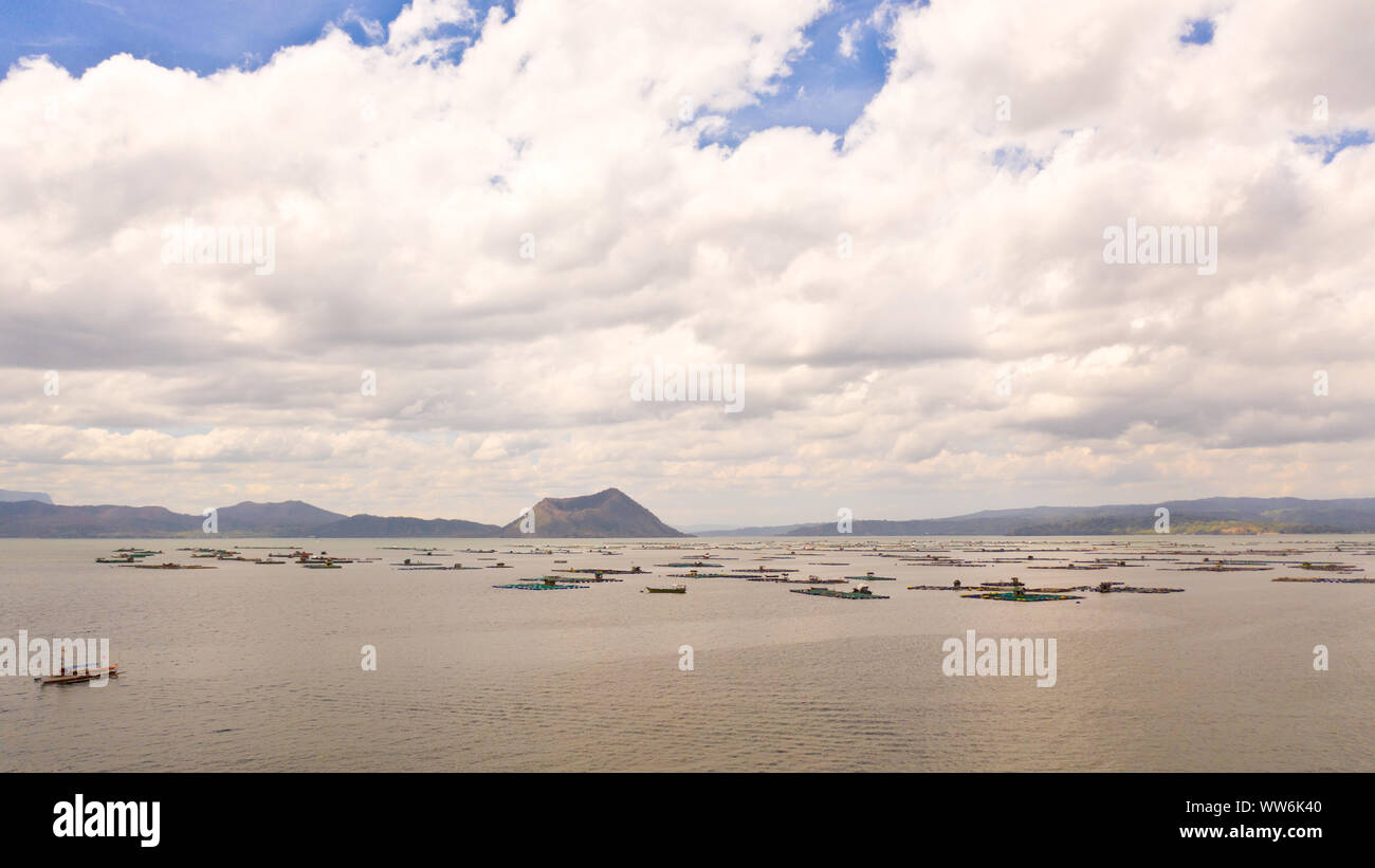 Lake Taal mit einem Vulkan und Fisch Käfigen auf eine Fischzucht, Ansicht von oben. Luzon, Philippinen tropischen Landschaft, Berge und Vulkan in den See. Stockfoto