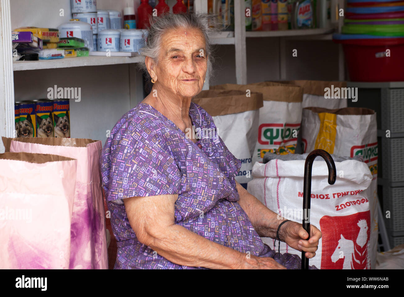 Alte griechische Frau sitzt in einem Geschäft in Griechenland Stockfoto