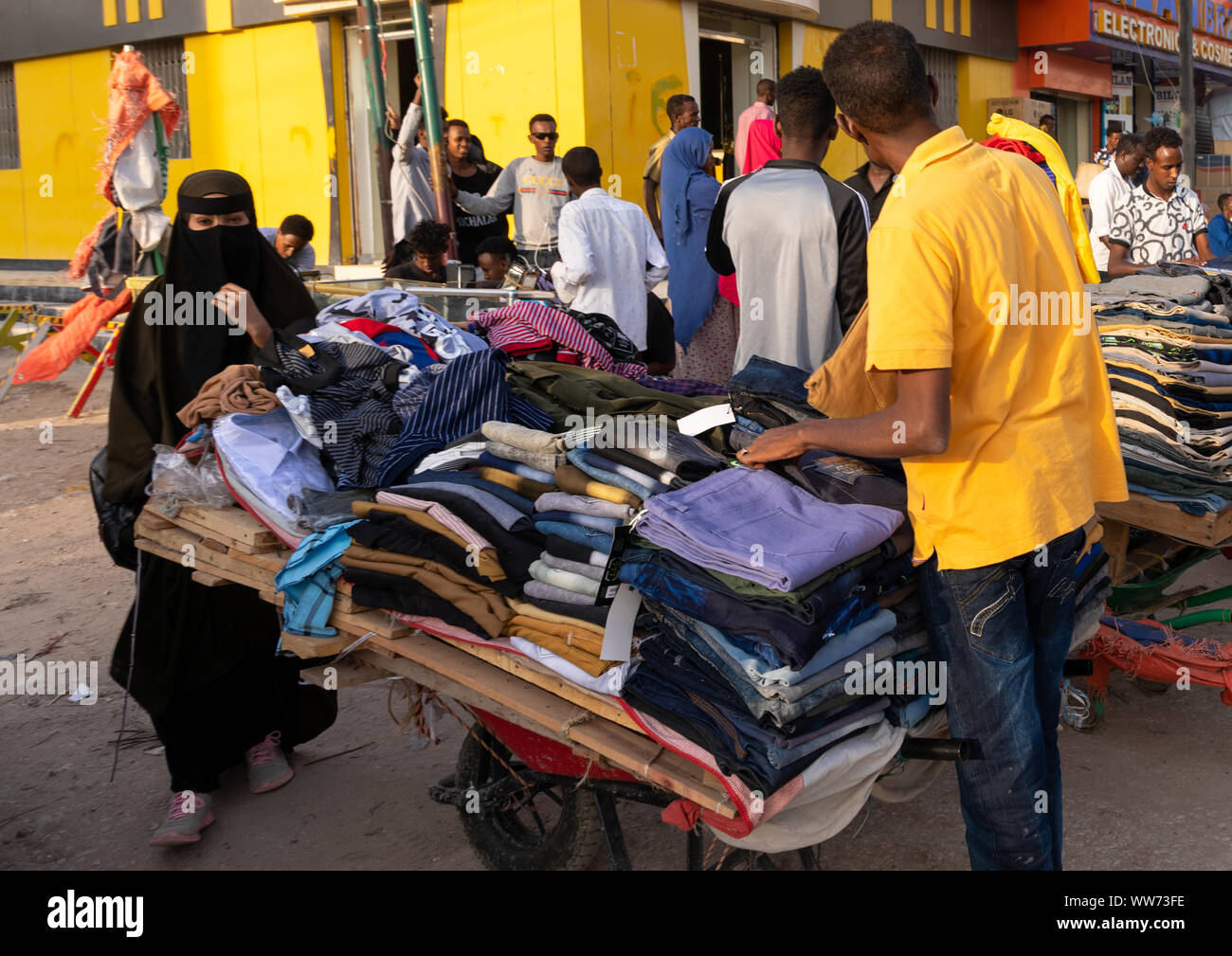 Die somalische Mann Verkauf von Kleidung zu einer Frau, die das Tragen einer Burka, Woqooyi Galbeed region, Hargeisa, Somaliland Stockfoto