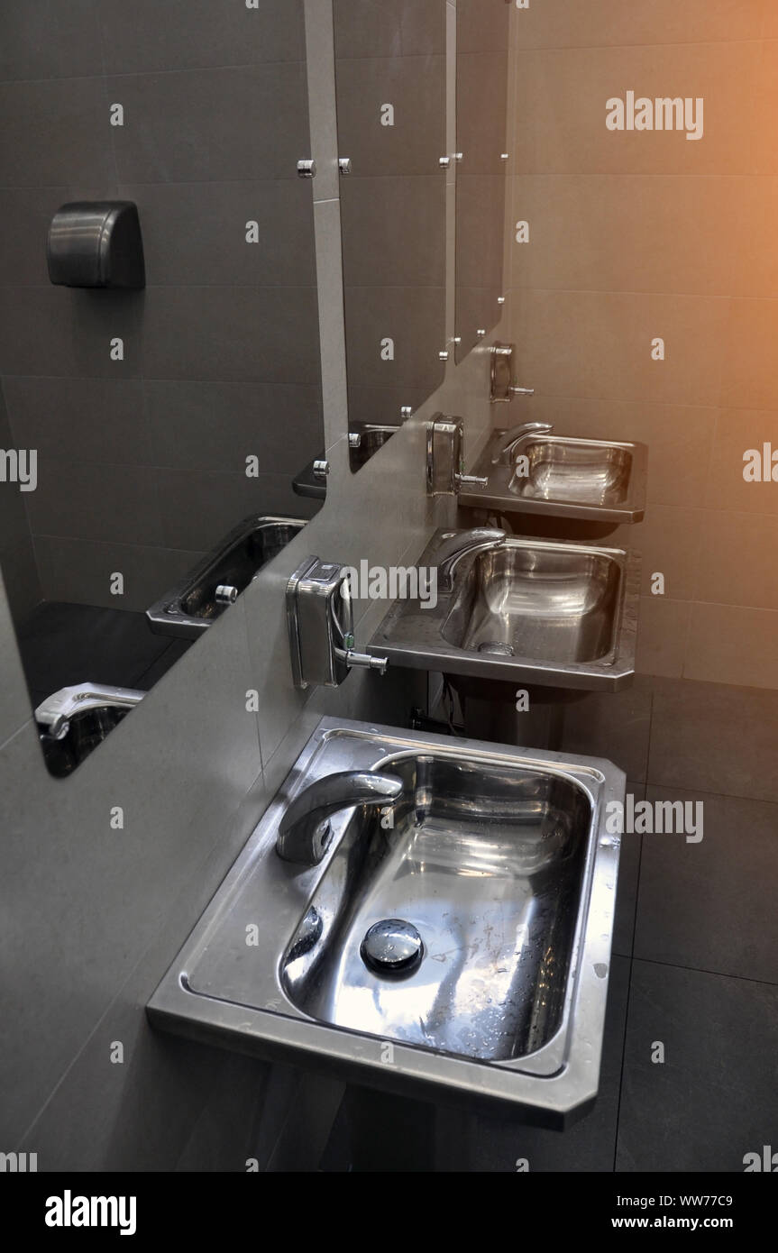Moderne Einrichtung einer öffentlichen Toilette. Edelstahl Waschbecken. Hygiene Stockfoto