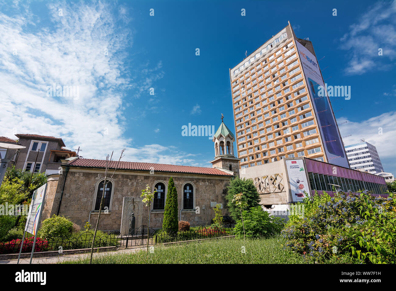 Burgas, Bulgarien - Juni 22, 2019: architektonische Kontraste mit einer alten armenischen Kirche und ein modernes Gebäude im Zentrum von Burgas, Bulgarien Stockfoto