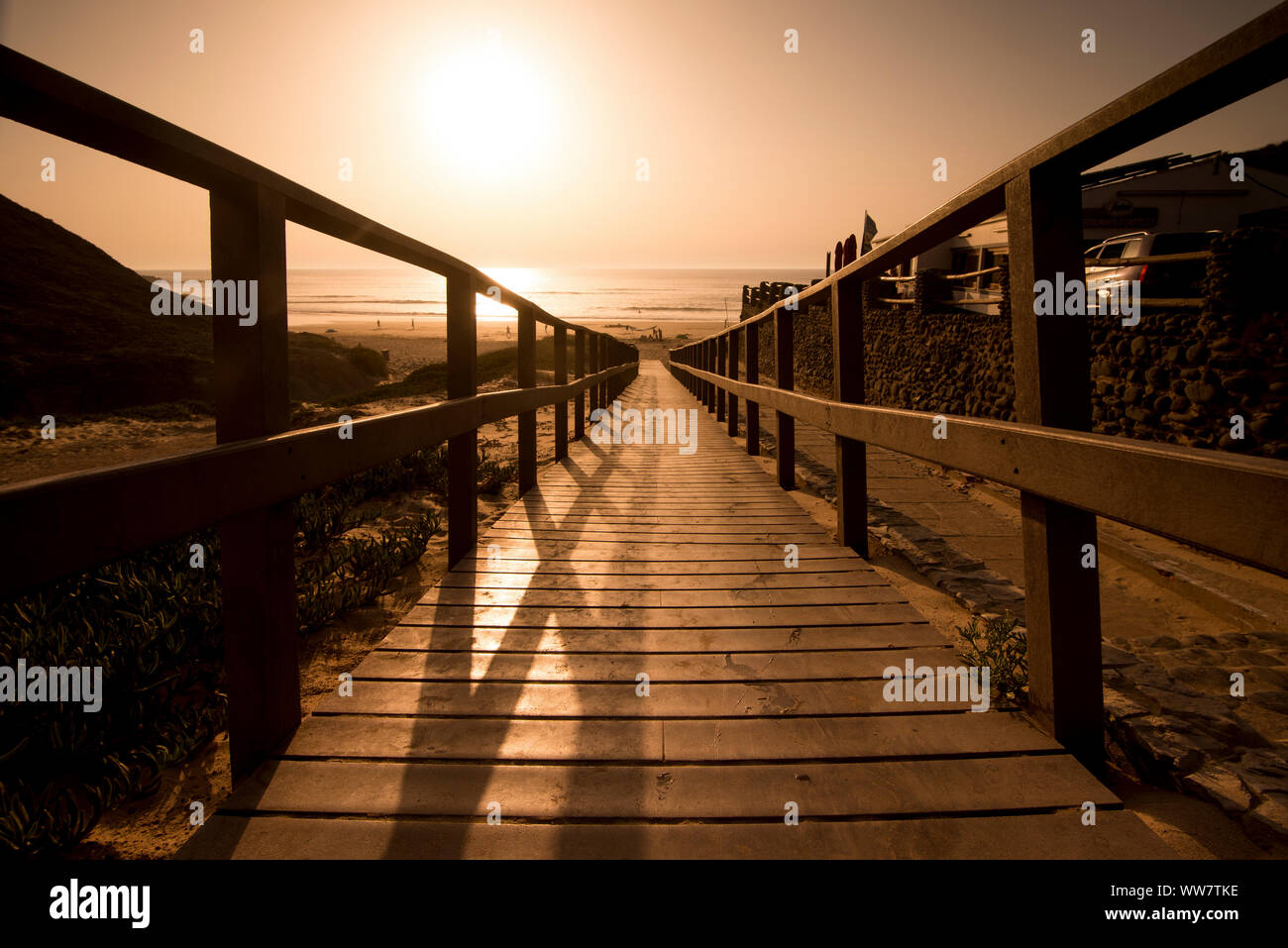 Sommersaison Pier während Ein farbenfroher Sonnenuntergang eingefangen. zu Fuß und zu Meer und Sandstrand gehen. Ferienhäuser und Konzept mit Stille entspannen. Licht und Schatten, Sonne im Hintergrund Stockfoto