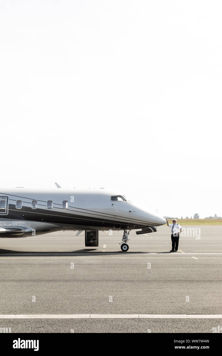 Co-pilot lehnte sich auf die Nase seines Jet beim Warten auf den nächsten Kunden. Stockfoto