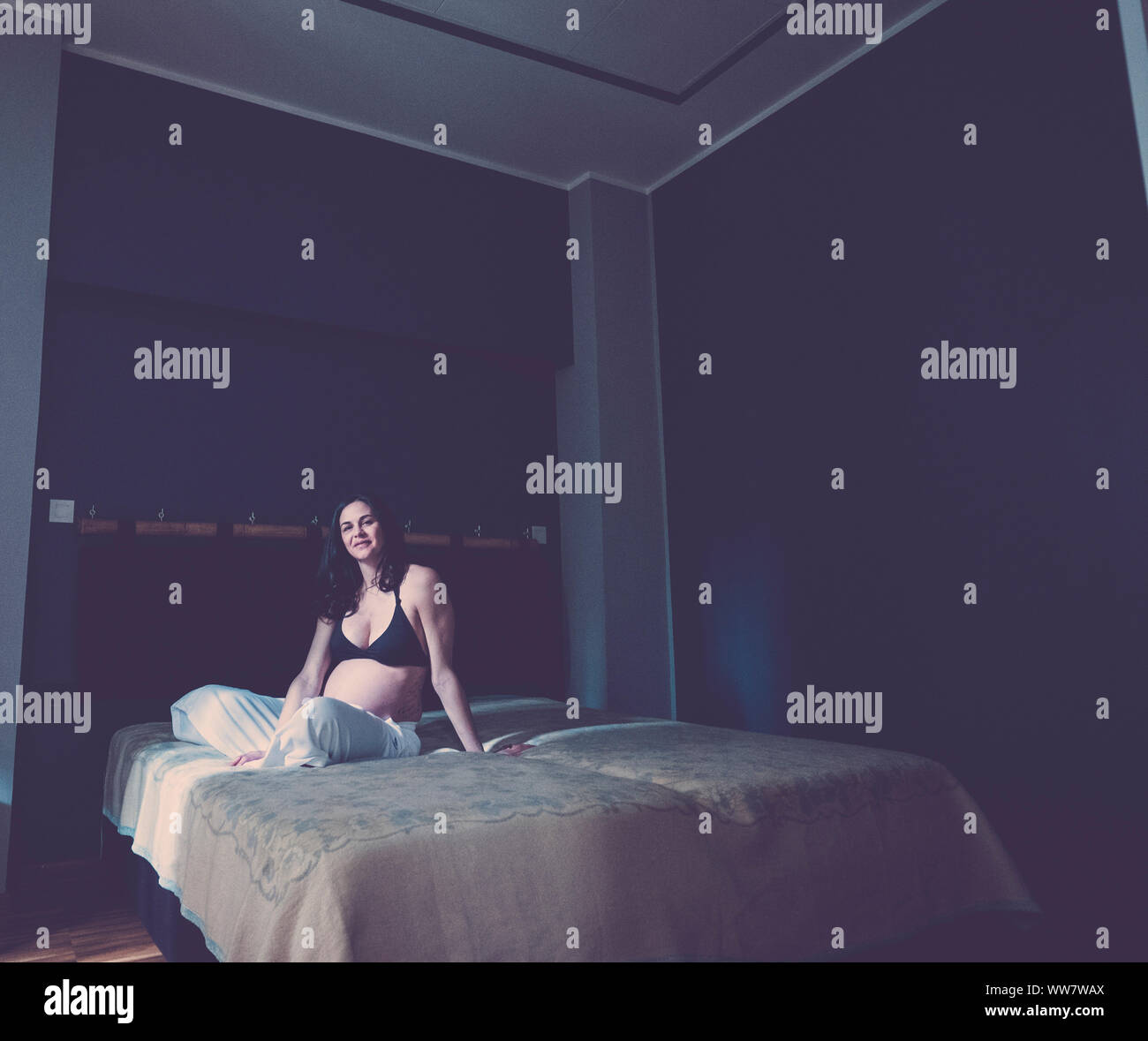 Schwangere schöne kaukasische Frau sitzt auf dem Boden und atmen zu entspannen. neues Leben Konzept zu Hause. Allein im Schlafzimmer Stockfoto