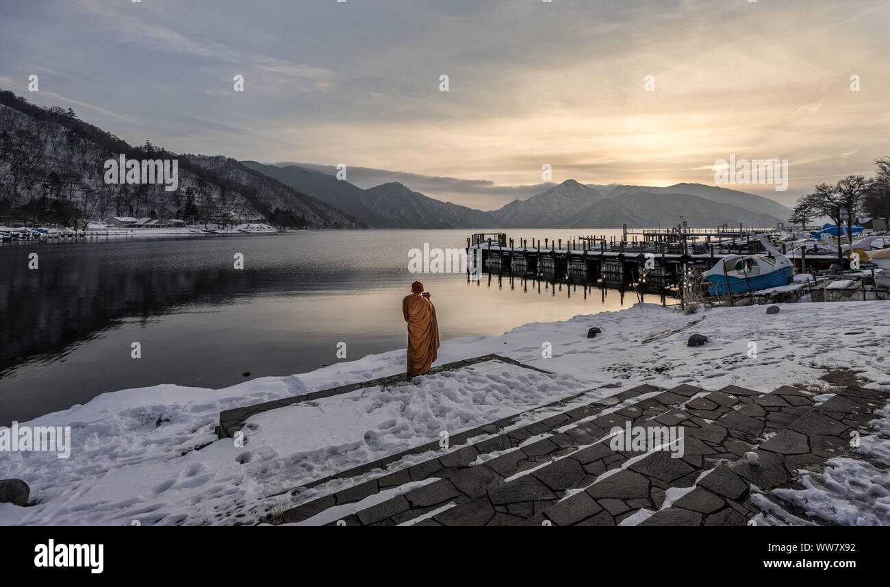 Ein theravada Mönch, die Bilder von Sonnenuntergang in der See Chuzenji, Nikko, Japan Stockfoto
