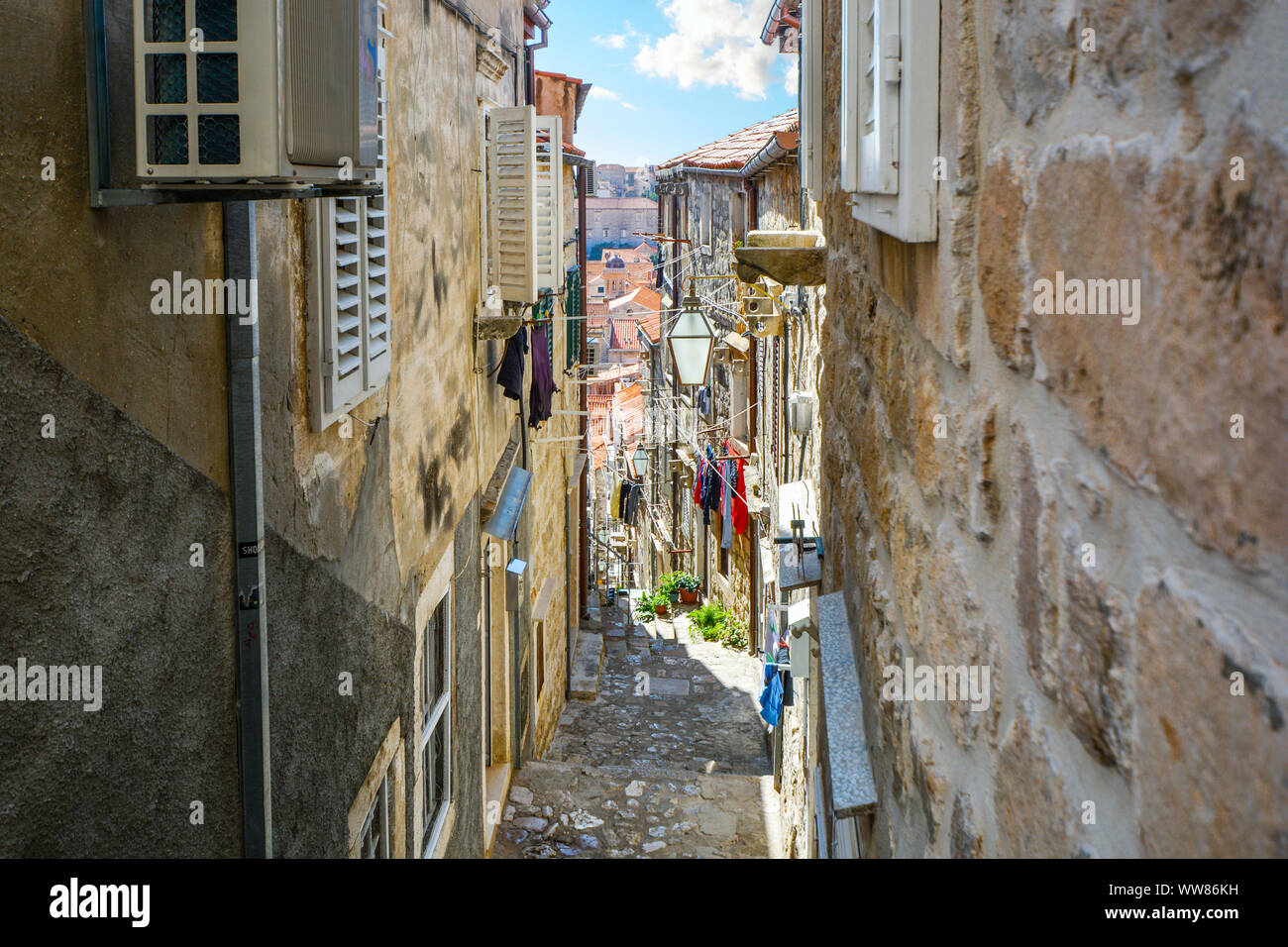 Bergab auf einem steilen und schmalen Straße in Dubrovnik, die von Mauern umgebene Stadt an der kroatischen Adriaküste. Stockfoto