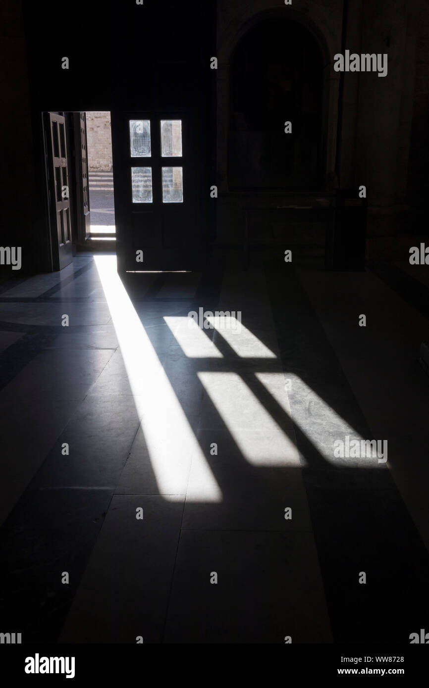 Die Schatten der vorderen Tür fallen auf dem Boden der Kirche Stockfoto