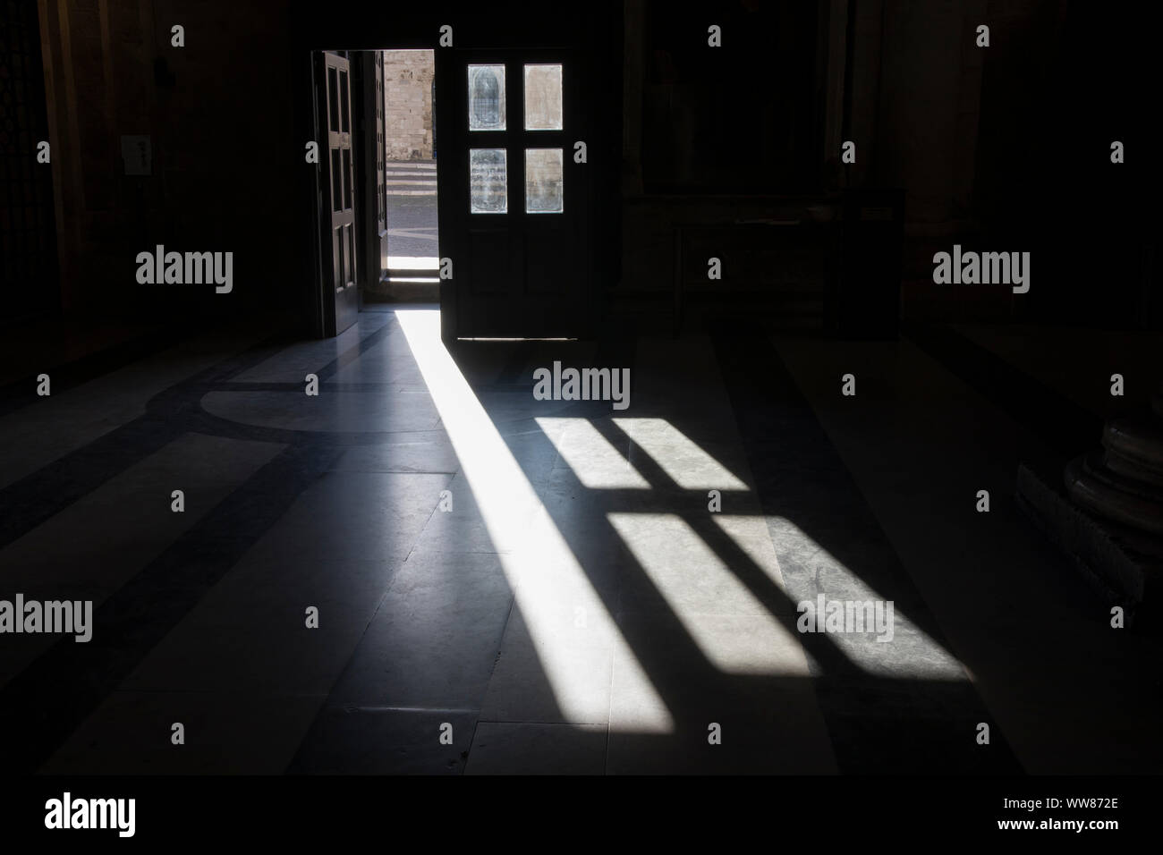 Die Schatten der vorderen Tür fallen auf dem Boden der Kirche Stockfoto