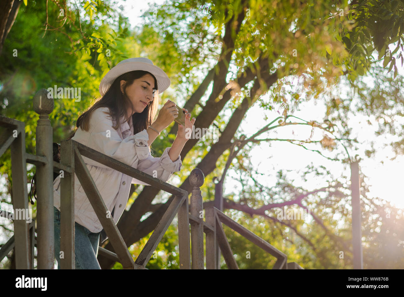 Junge Frau nimmt ein Bild mit Ihrem Smartphone in einem Park. Freizeit, Lifestyle, Technik Stockfoto