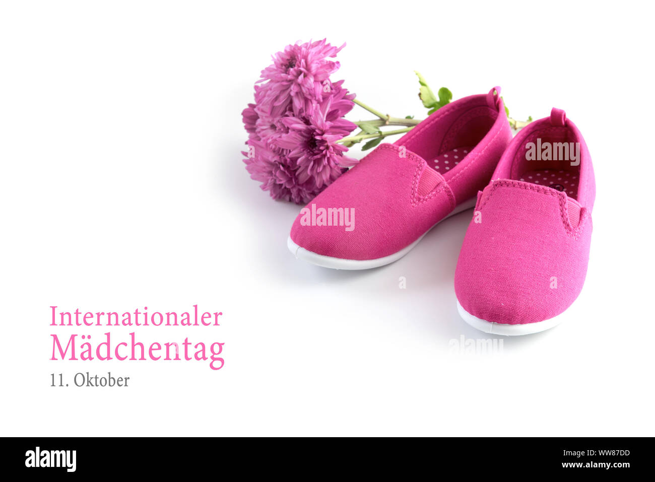 Rosa kid Schuhe und eine Blume auf einem weißen Hintergrund, deutsche Text Internationaler Maedchentag 11. Oktober, dem Internationalen Tag des Gi Stockfoto