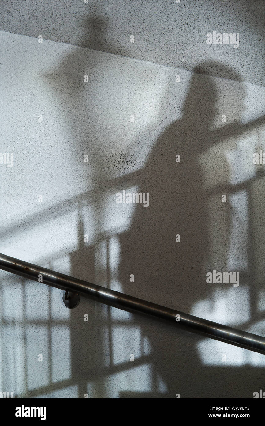 Zusammenfassung Hintergrund der Schatten Mann zu Fuß die Treppe hinauf und Straße Licht auf eine weiße Wand. Stockfoto