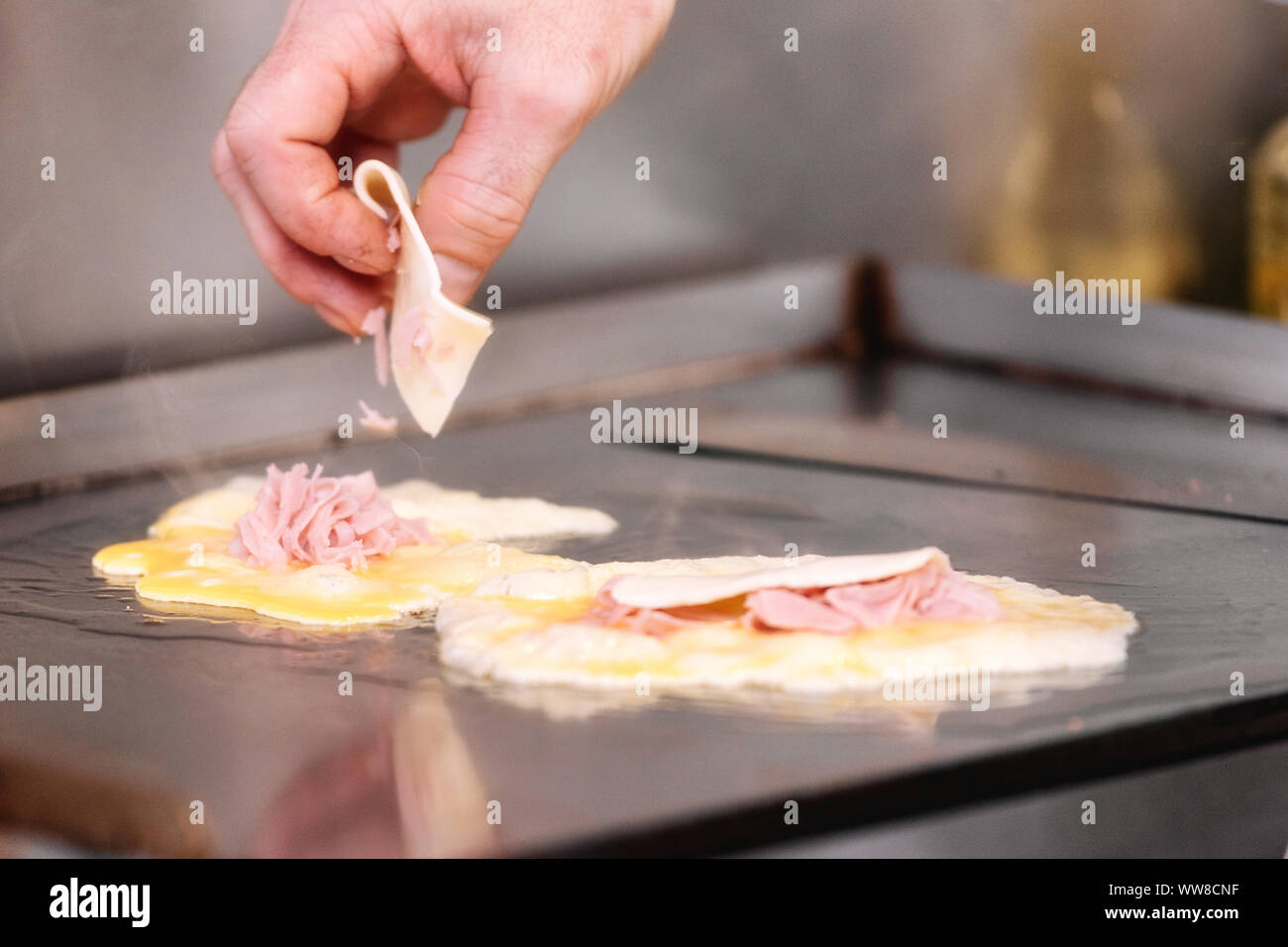 Küchenchef köstliche Omelette mit Schinken und Käse. Stockfoto