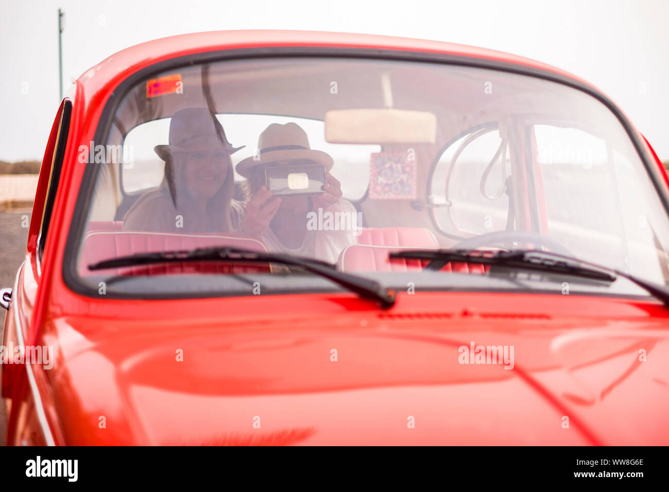Freundliche Damen mittleren Alters kaukasischen Menschen mit rot Retro Auto, alternative Lifestyle zu Reisen und das Leben geniessen Stockfoto
