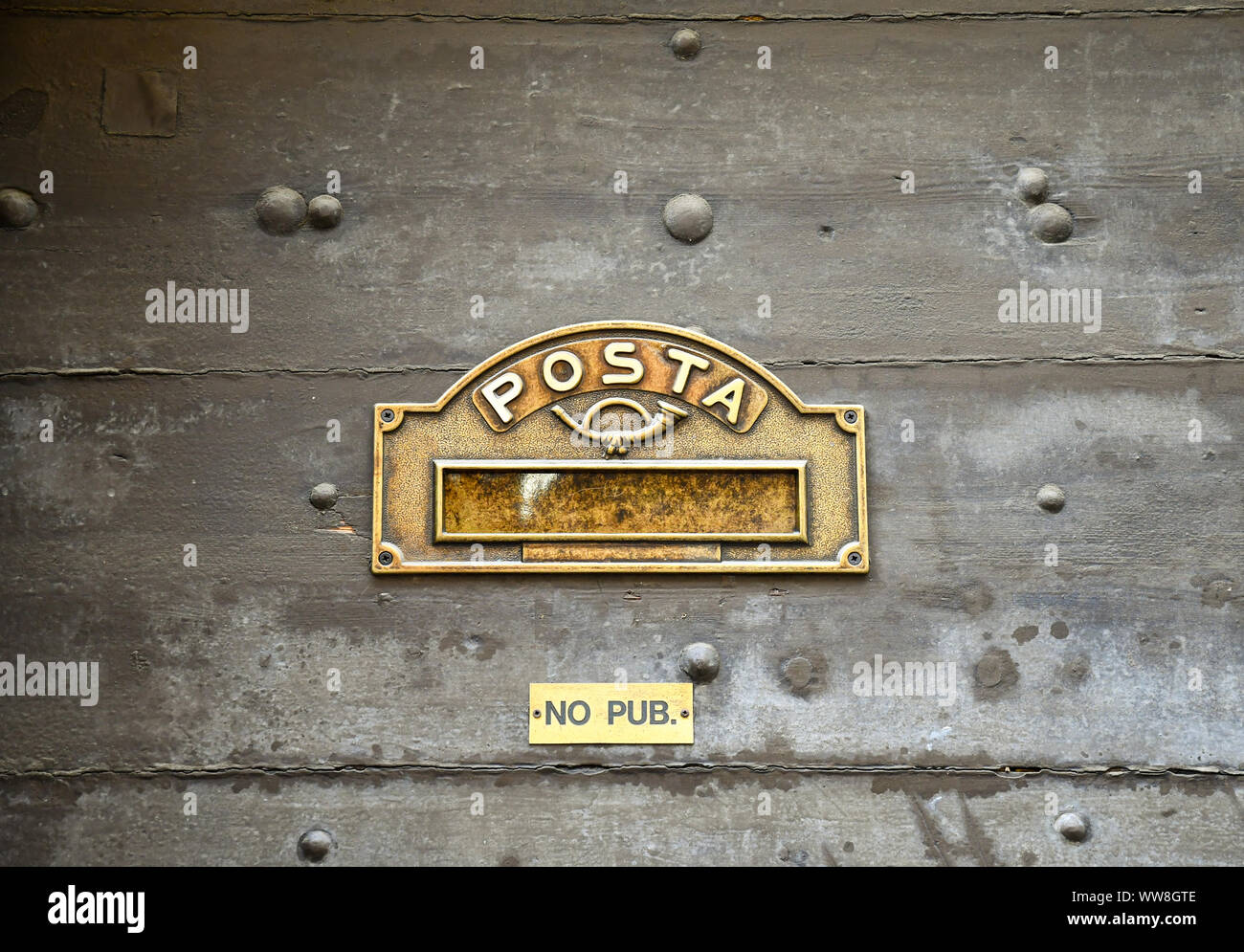 In der Nähe von eine alte Holztür mit Eisen Bolzen, einen Brief Platz mit Horn und eine kleine Platte, die sagt: "Keine Werbung", Aosta, Aostatal, Italien Stockfoto