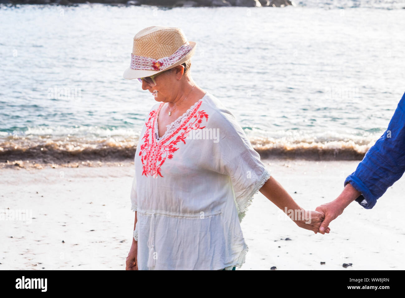 Folgen Sie und kommen Sie mit mir Frau Mann Hand zusammen am Ufer am Strand zu Laufen. Blick auf das Meer im Hintergrund für Liebe und Ferienhäuser Konzept Stockfoto Folgen Sie und kommen Sie mit mir Frau Mann Hand zusammen am Ufer am Strand zu Laufen. Blick auf das Meer im Hintergrund für Liebe und Ferienhäuser Konzept Stockfoto