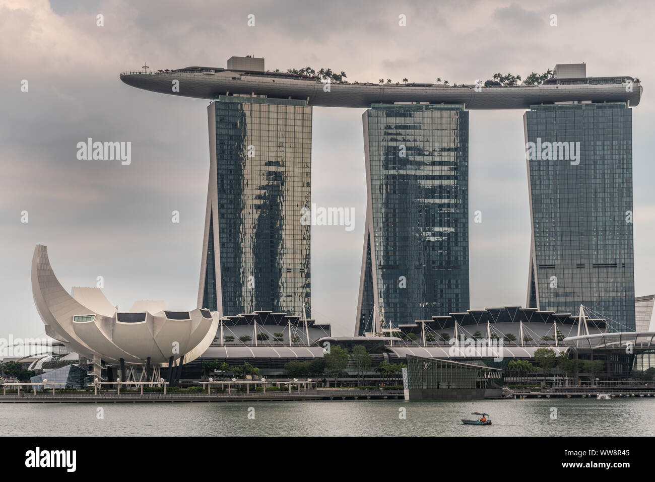 Singapur - März 20, 2019: Marina Bay Sands Hotel und Casino mit seinen drei Türmen von hinter der Bucht unter regnerischen Schwere cloudscape gesehen. Weißes Oberteil ist Stockfoto