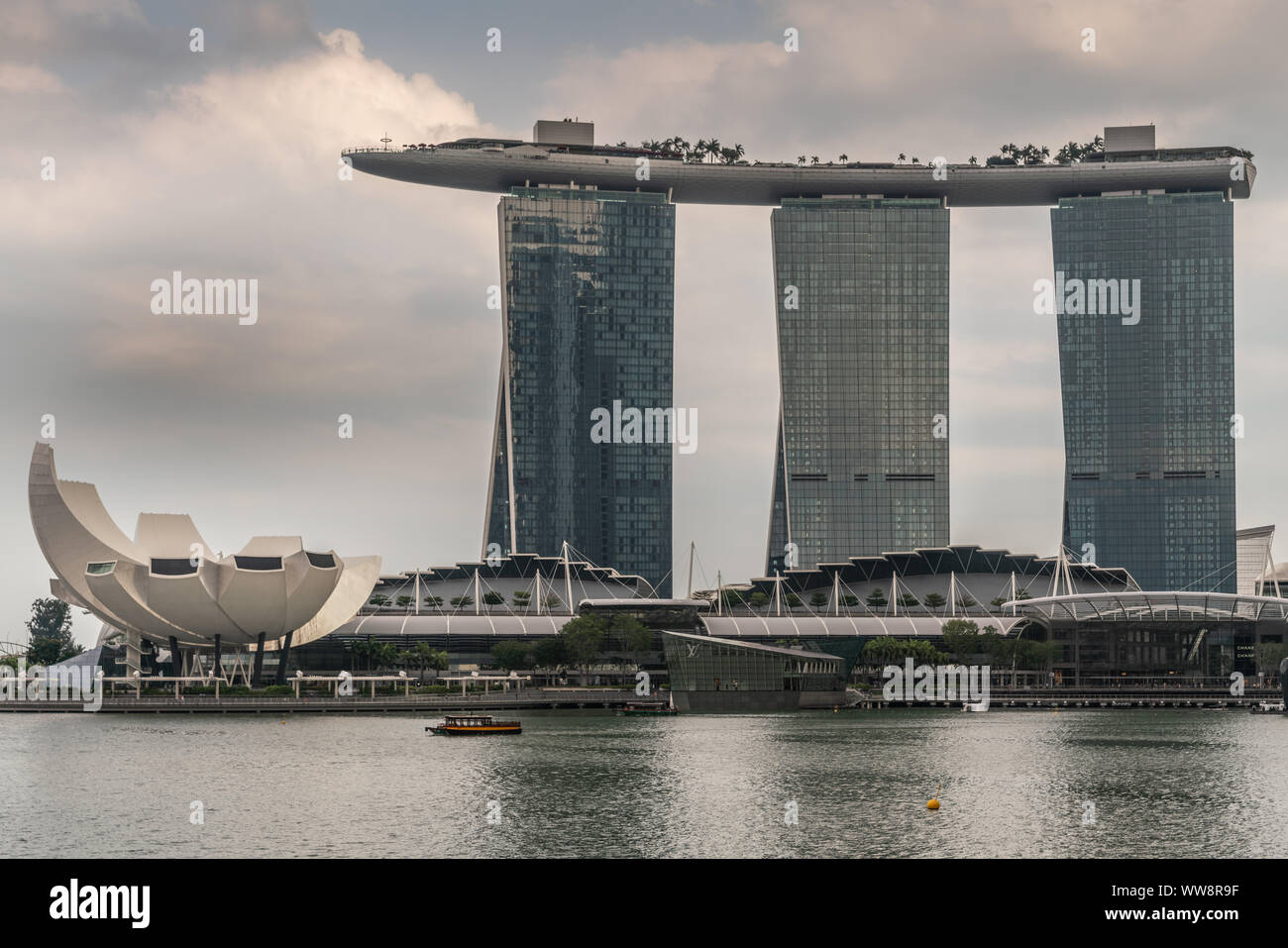 Singapur - März 20, 2019: Marina Bay Sands Hotel und Casino mit seinen drei Türmen von hinter der Bucht unter regnerischen Schwere cloudscape gesehen. Weißes Oberteil ist Stockfoto
