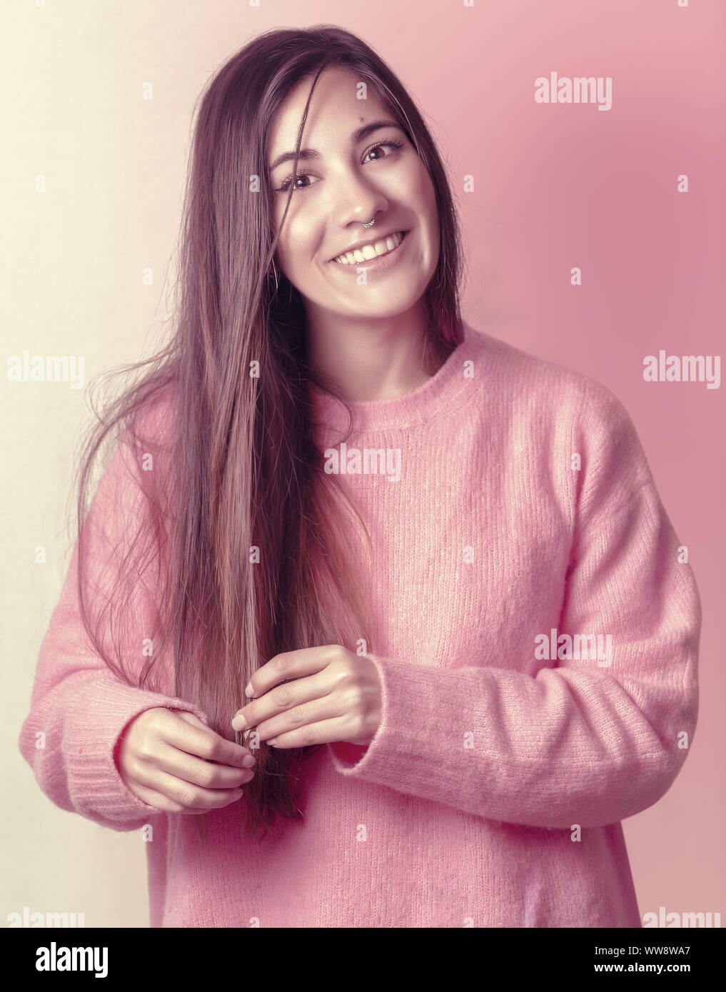 Hübsches Mädchen mit geradem Haar und einen rosa Pullover Stockfoto