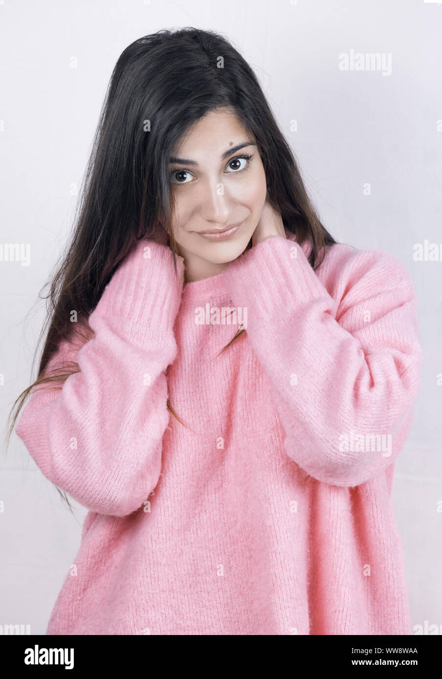 Hübsches Mädchen mit glattem Haar und einem warmen rosa Pullover Stockfoto