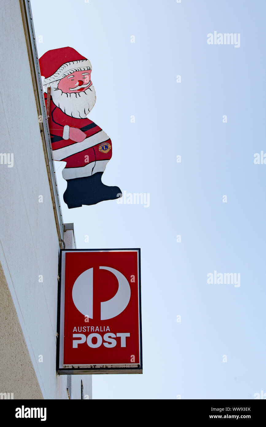 Ein Santa, Weihnachten Dekoration sitzt über einem Australien post Zeichen außerhalb des Ulladullla Post in New South Wales, Australien Stockfoto