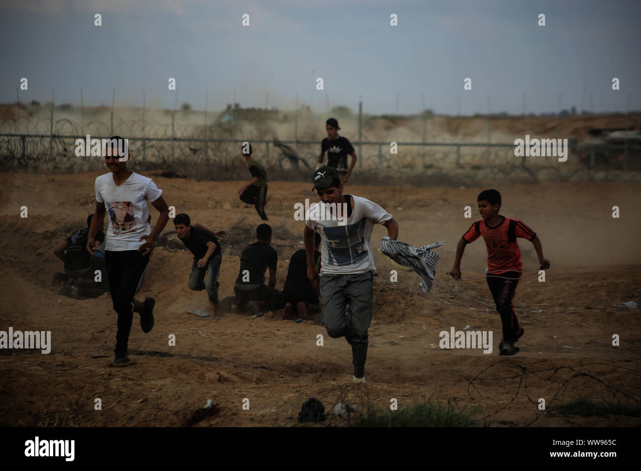 Gaza, Palästina. 13 Sep, 2019. Palästinensische Demonstranten aus tränengaskanister reißen die Flucht in Richtung zu Ihnen während einer anti-israelischen Demonstration an der Israel-Gaza Grenzzaun im südlichen Gazastreifen abgefeuert. Credit: SOPA Images Limited/Alamy leben Nachrichten Stockfoto