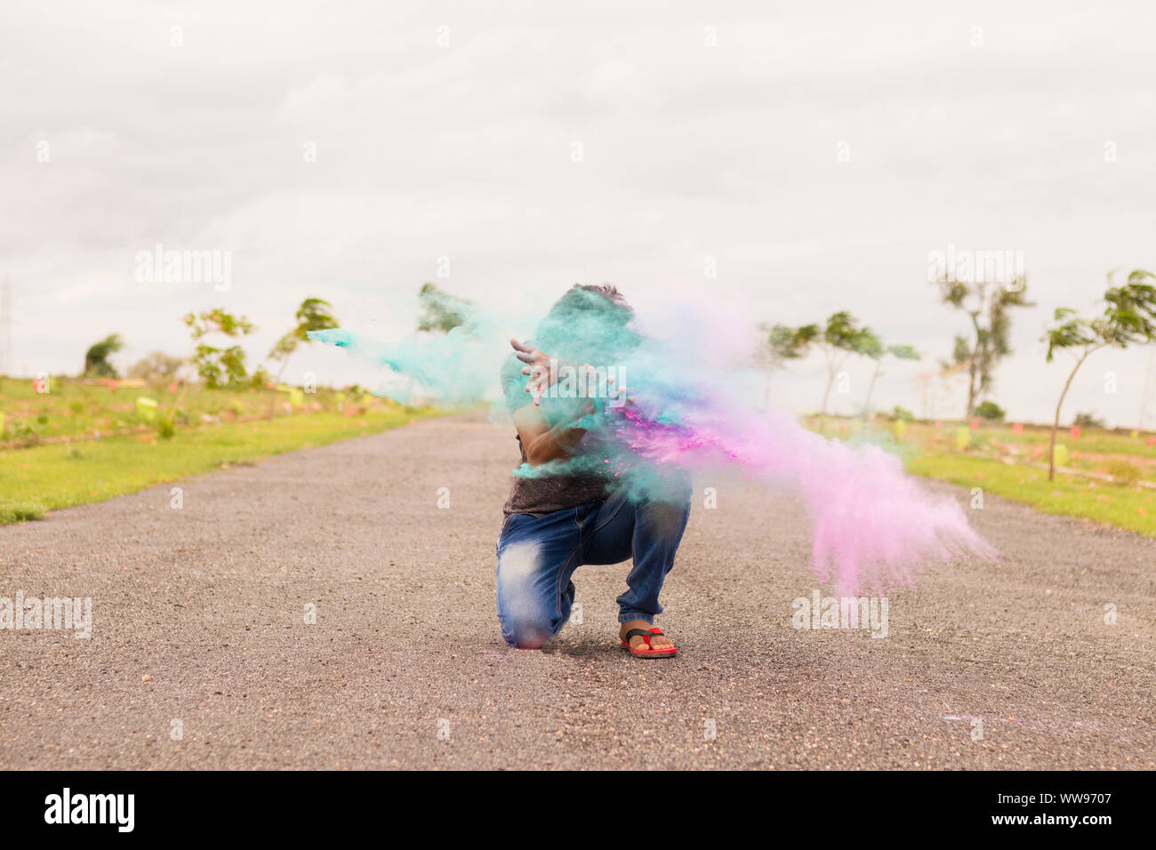 Konzept der Holi Festival, Mann explodieren Bunte Pulver in der Hand auf der Straße. Stockfoto