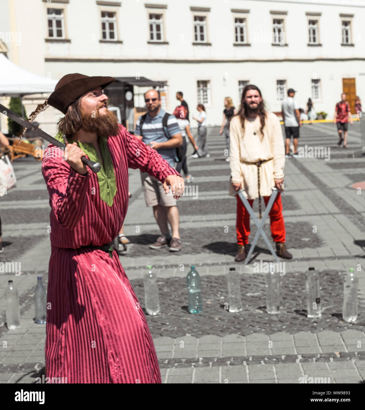 Stadt Sibiu, Rumänien - 25 August 2019. Ein Mann wie ein mittelalterlicher Ritter gekleidet schneidet eine unterschiedliche Objekte mit seinem Schwert auf traditionelle mittelalterliche Festival 2019 Stockfoto