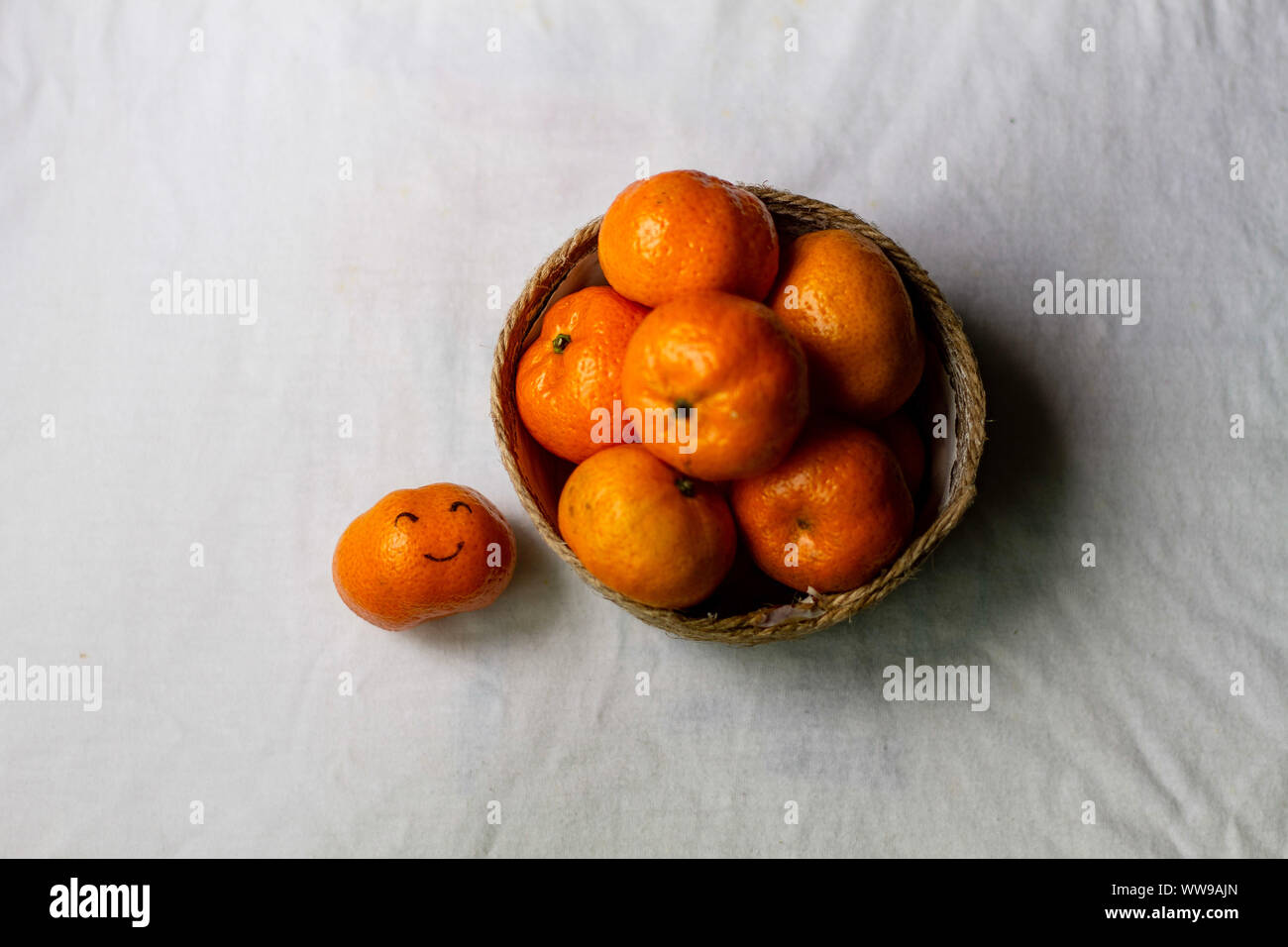 Blick von oben auf einen Korb voller Clementine-Orangen, der das Konzept von Sommer, gesundem, nachhaltigem Lebensstil und Wellness zeigt Stockfoto
