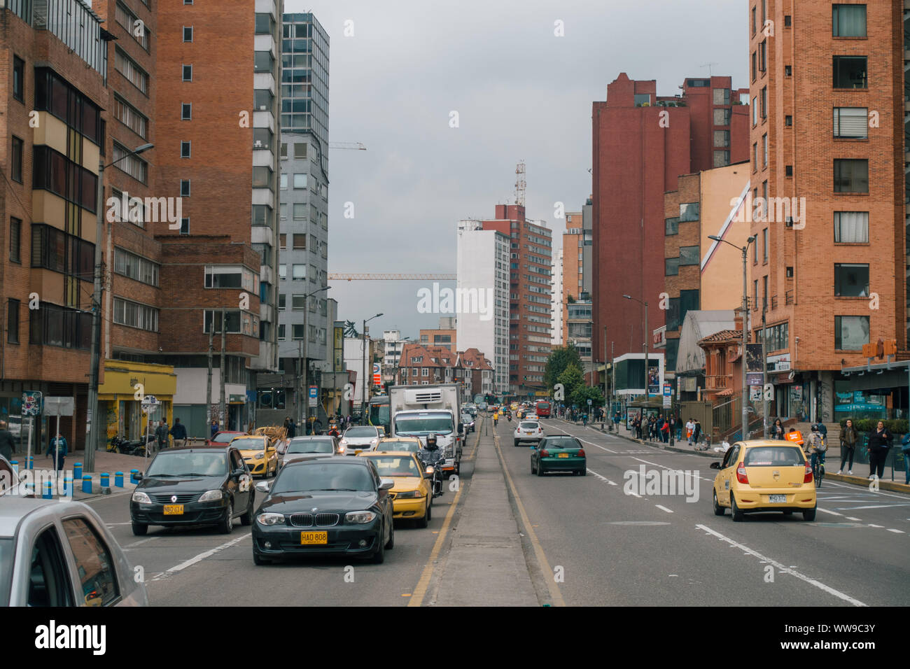 Den Blick von der Mitte der Hauptstraße als Verkehr passieren bei rush hour in Chapinero, Bogotá, Kolumbien Stockfoto