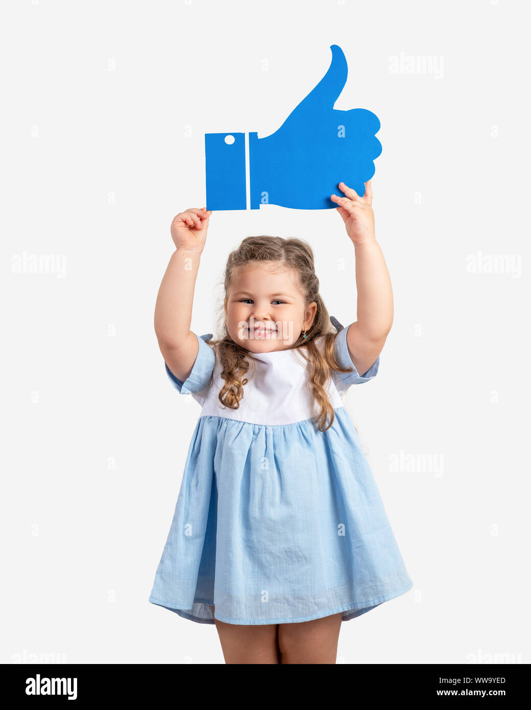 Kleine süße Mädchen holding Cartoon wie auf grauem Hintergrund. Social Media Konzept. Stockfoto