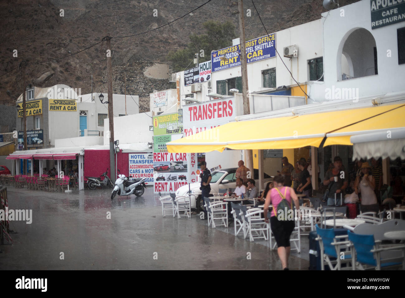 Santorini, Griechenland - 26. Juni 2018: Touristen warten, ein Sommer Regen in einem Port-Cafe auf der Insel Santorini. Stockfoto