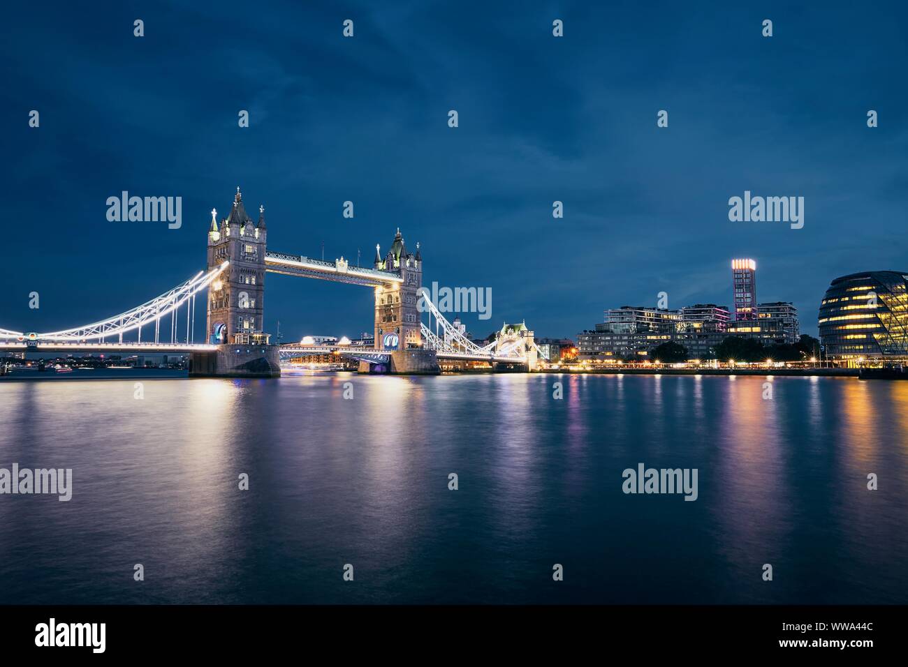 Nacht Blick von der Tower Bridge gegen Stadtbild mit Rathaus bei Nacht. London, Vereinigtes Königreich. Stockfoto