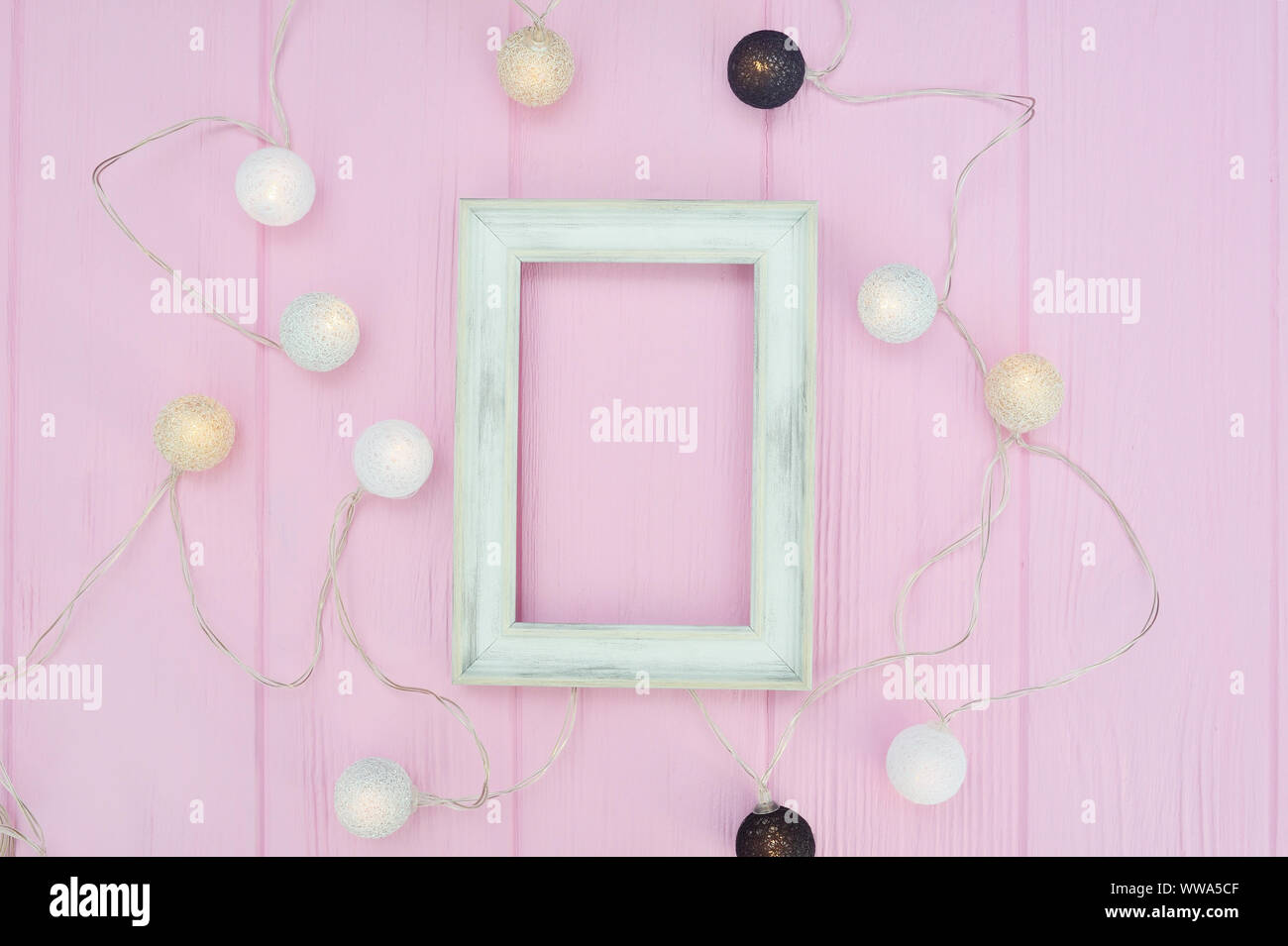 Weiße Holzrahmen mockup mit Platz für Text. Girlande auf rosa Hintergrund Holz im skandinavischen Stil. Für Artwork, Drucke oder Foto Stockfoto