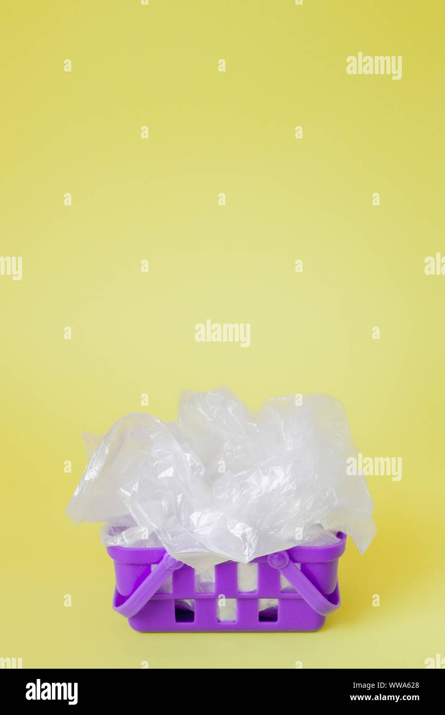 Polyäthylenbeutel im Warenkorb auf gelben Hintergrund. Stockfoto