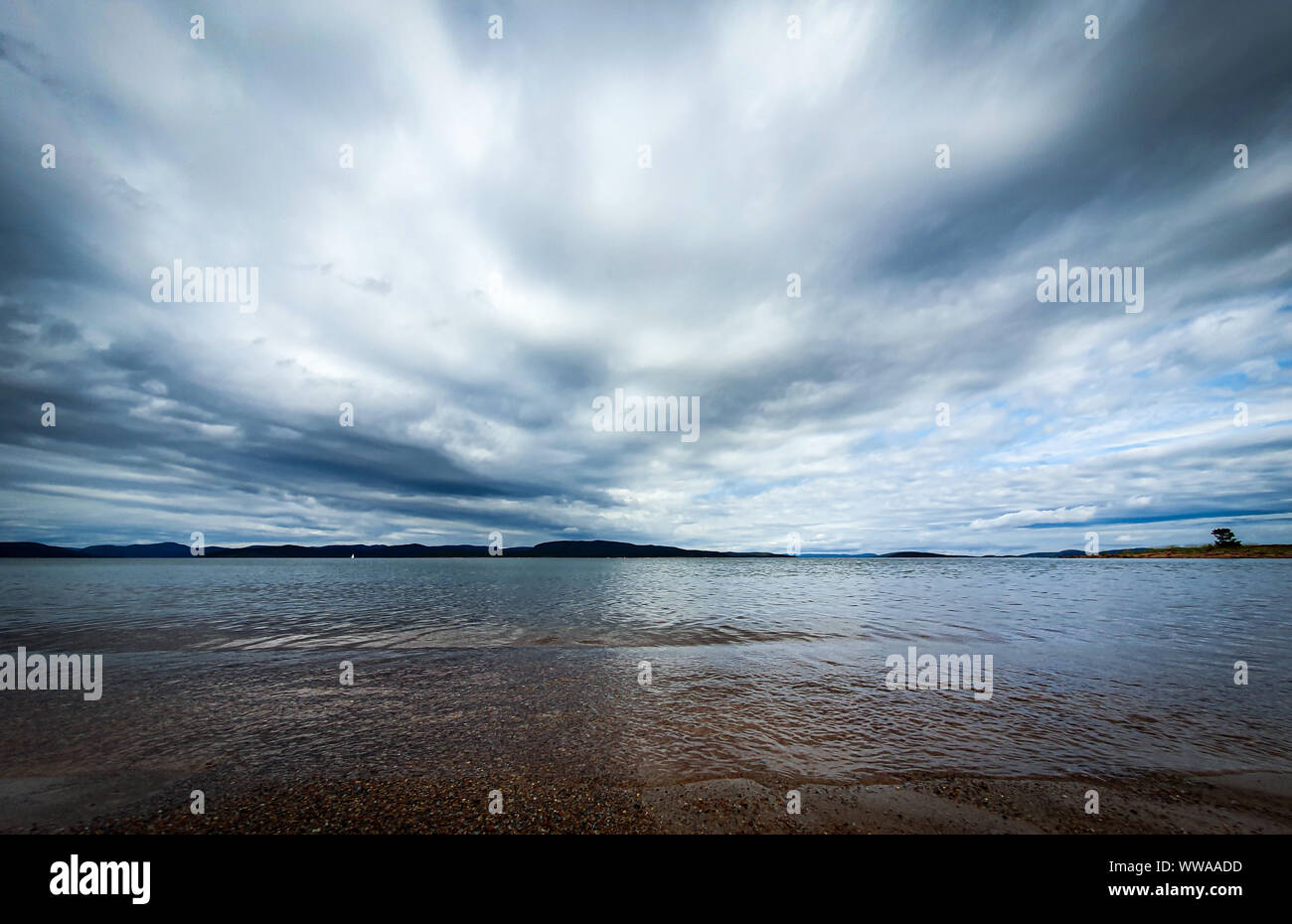 Dramatische Himmel über schönen ruhigen Wasser im Bottnischen Meerbusen. Storsand, Hohe Küste im Norden Schwedens. Stockfoto