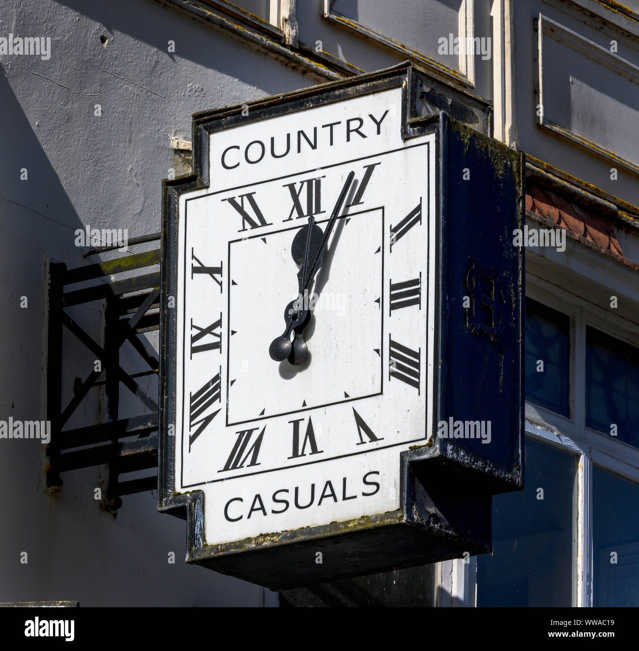 Eine öffentliche Uhr an der Wand von 20 Inglis Street, Inverness, Schottland, UK mit und Werbung für Land Casuals. Stockfoto